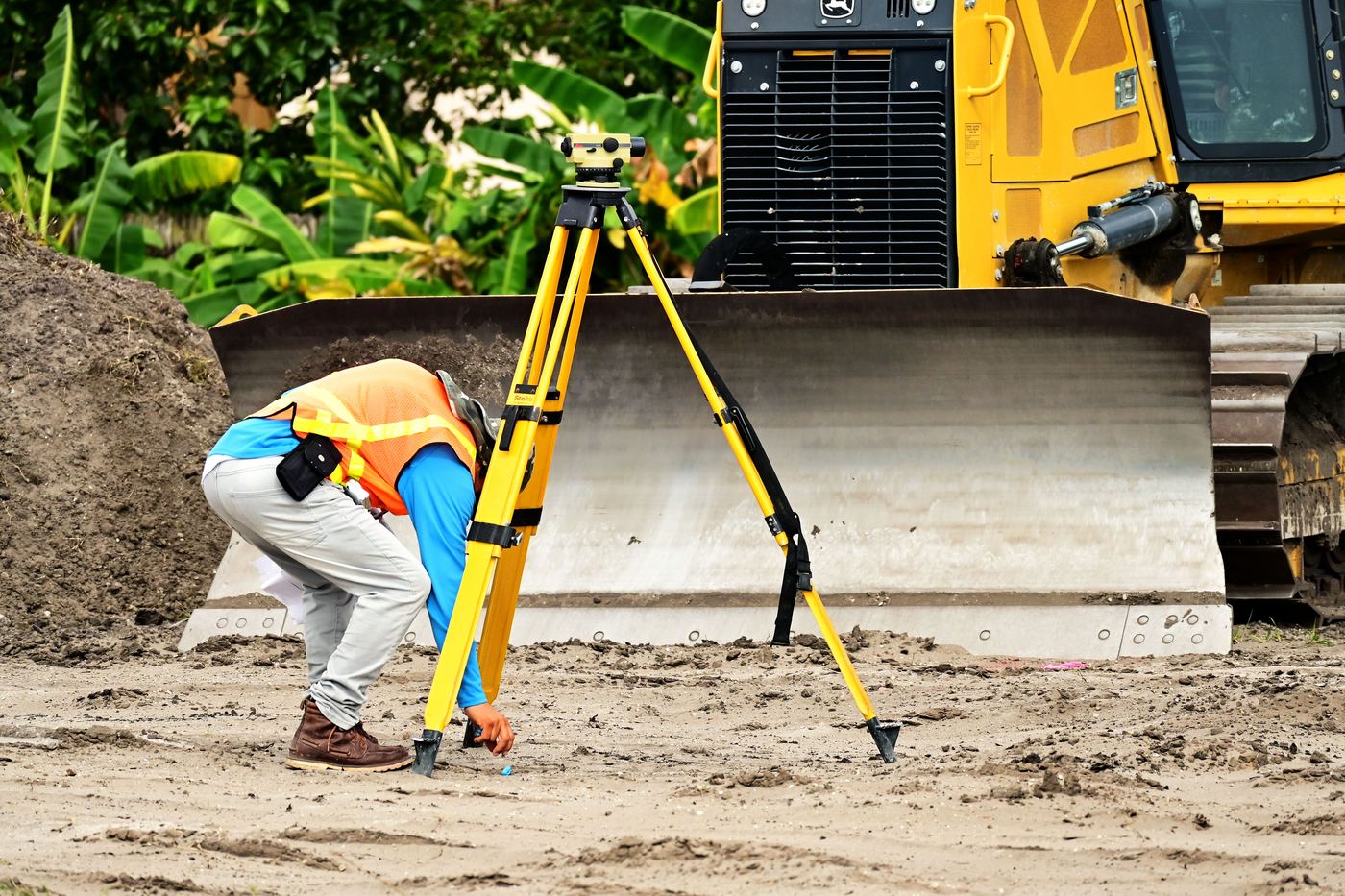 Surveyor setting up a total station on a construction site